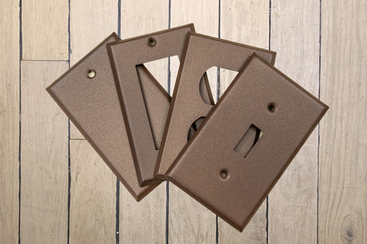 Walnut Texture powder coated Toggle, Rocker, Duplex, and Blank standard size metal switch plates.  Dark brown outlet cover